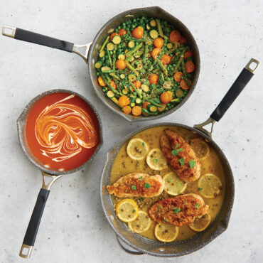 Lifestyle image of 8" ceramic nonstick skillet with tomato soup, 10" ceramic nonstick skillet with sautéed vegetables and 12" ceramic nonstick skillet with pasta