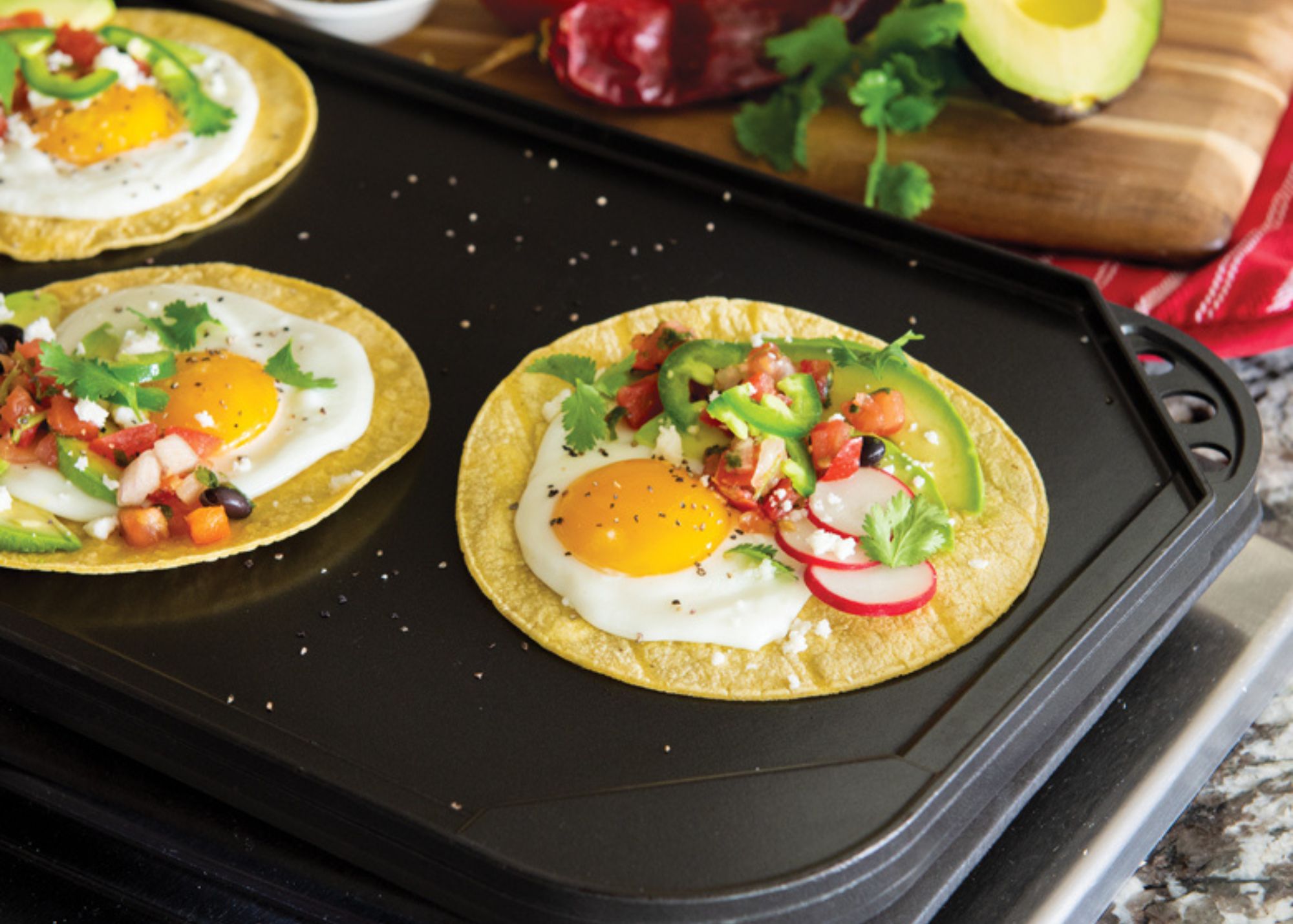 Breakfast tacos on large flat griddle on stovetop