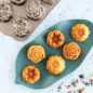 Baked mini Floral cakelets on a leaf platter with pan in background.