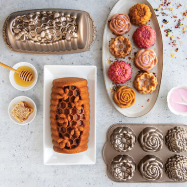 Spring baking scene with baked floral cakelets on a plate with glaze and a honey hive loaf cake.