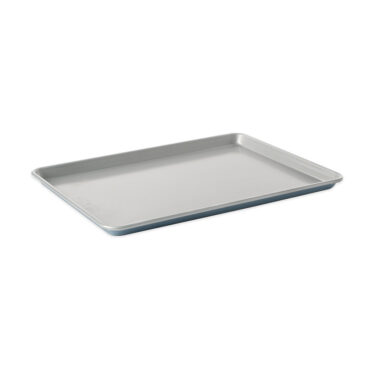 Nordic Ware aluminum half sheet baking pan with raised rim, natural silver finish, angled view