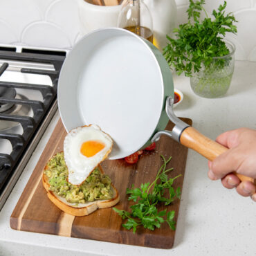 Nordic Ware 8-inch cardamom ceramic nonstick skillet with raw egg being poured over avocado toast