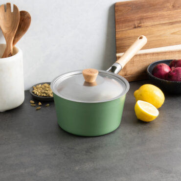 Nordic Ware 3-quart cardamom non-stick saucepan with lid, displayed with cooking ingredients and wooden utensils