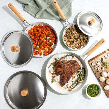 Overhead image of Cardamom 6 piece fry pan and lid set, steak, carrots and mushrooms in pans