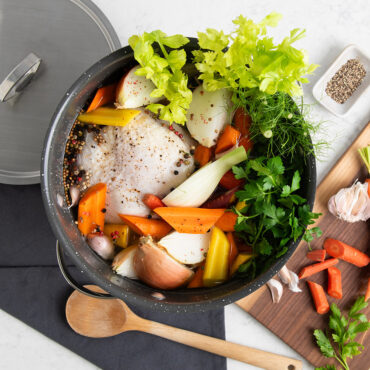 Verde 12 Qt Stockpot with Lid on countertop with veggies; overhead