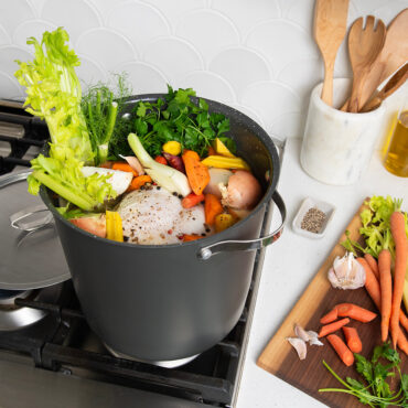 Verde 12 Qt Stockpot with Lid on stovetop with veggies