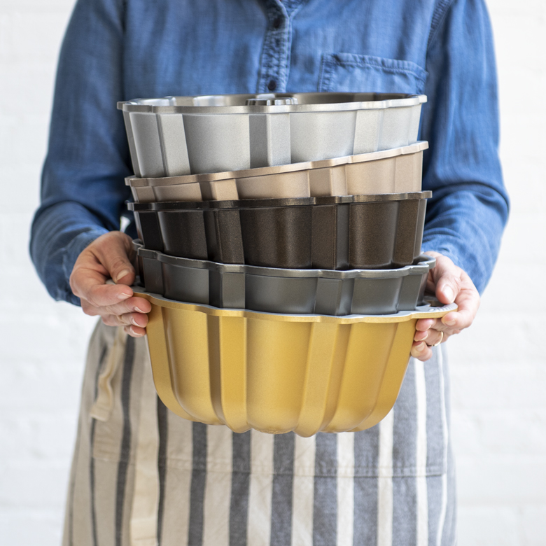 Image of a person holding 4 different Bundt Pans