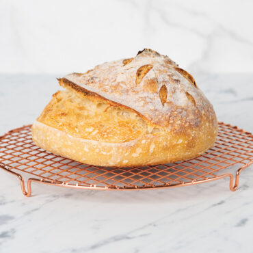 Baked Sourdough Bread on a cooling rack in kitchen