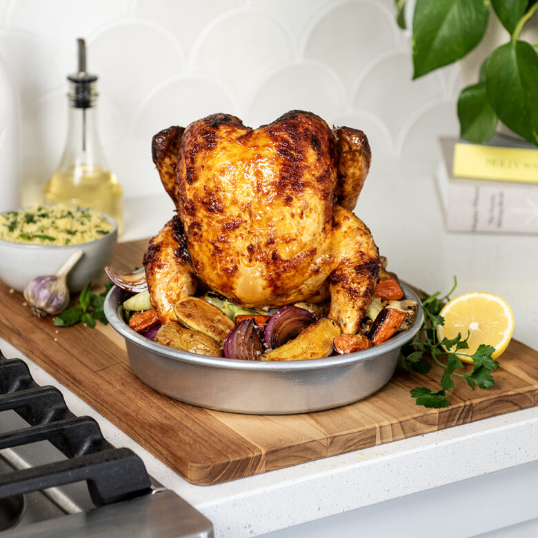  Image of cooked whole chicken and veggies in Nordic Ware's Vertical Chicken Roaster.