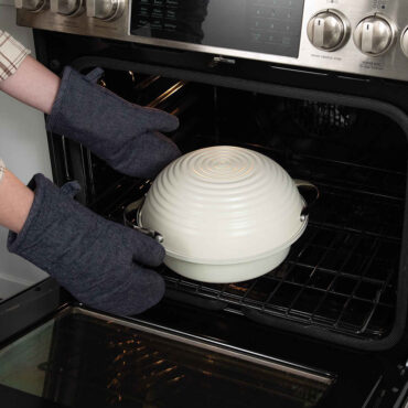 Covered pan being placed inside an oven