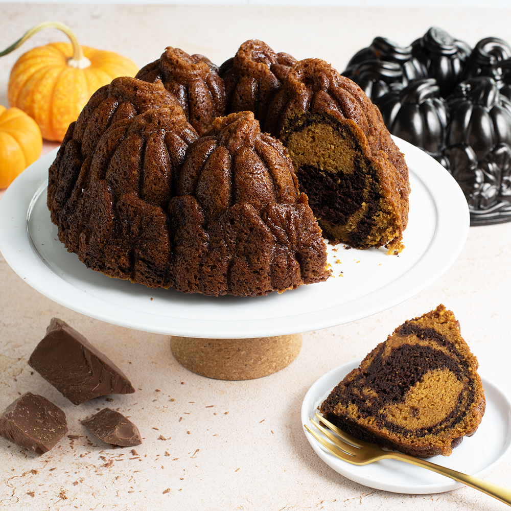Image of a baked pumpkin chocolate marble Bundt cake baked in Nordic Ware's Pumpkin Patch Bundt Pan in a Fall scene.