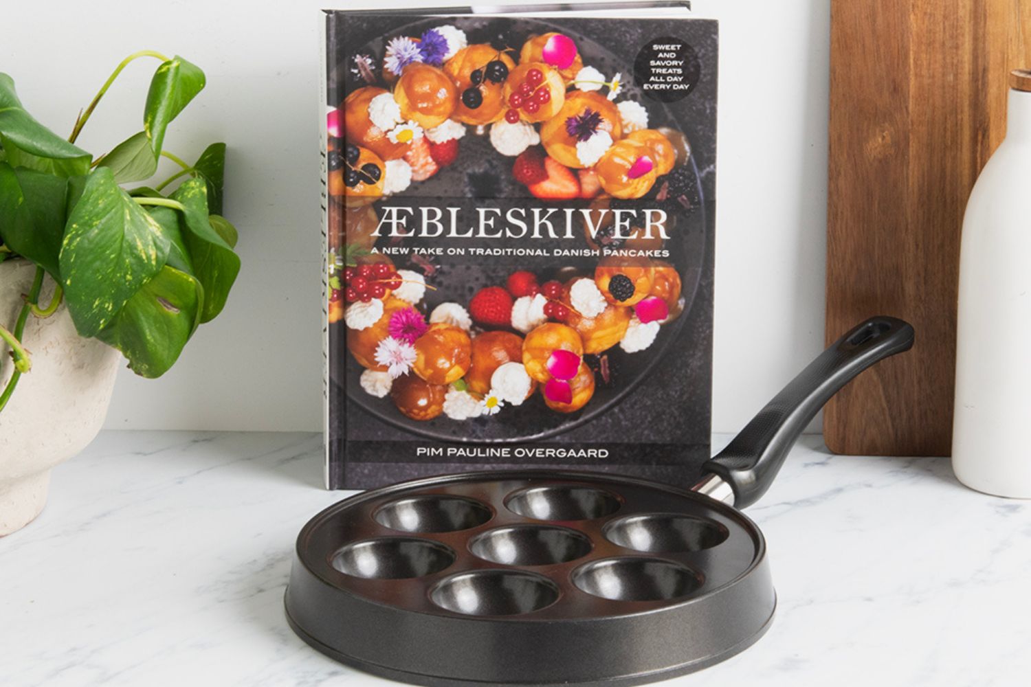 Danish Ebelskiver Pan and Aebleskiver cookbook by Pim Pauline Overgaard in a kitchen.