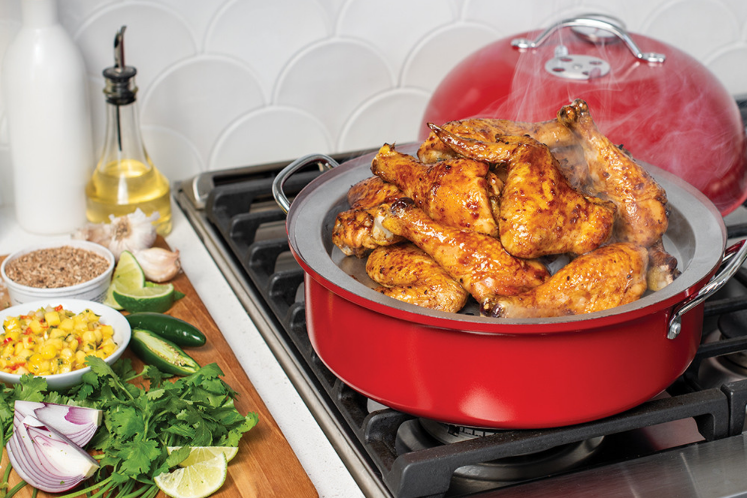 Kettle Smoker smoking chicken wings and drumsticks on the stovetop.