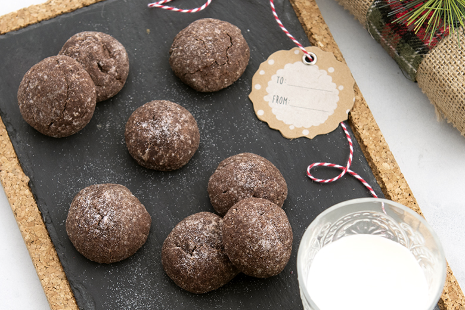 Chocolate Almond Sparkle Cookies on a serving board with a glass of milk. 