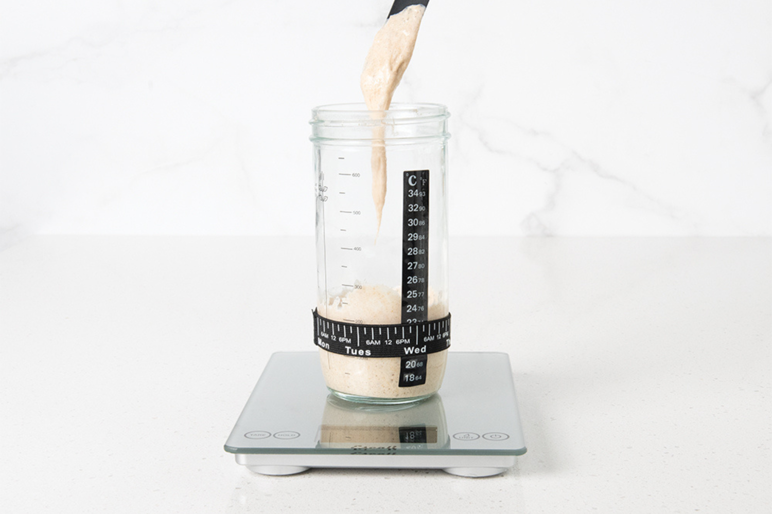Weigh & feed start culture in the Glass Starter Jar with Temp Strip & Tracker Band from the Simply Sourdough Bread Baking Kit.