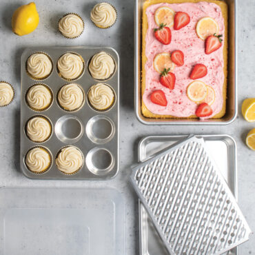 overhead view of naturals 5 piece bakeware set with cupcakes in muffin pan and frosted cake in rectangular pan