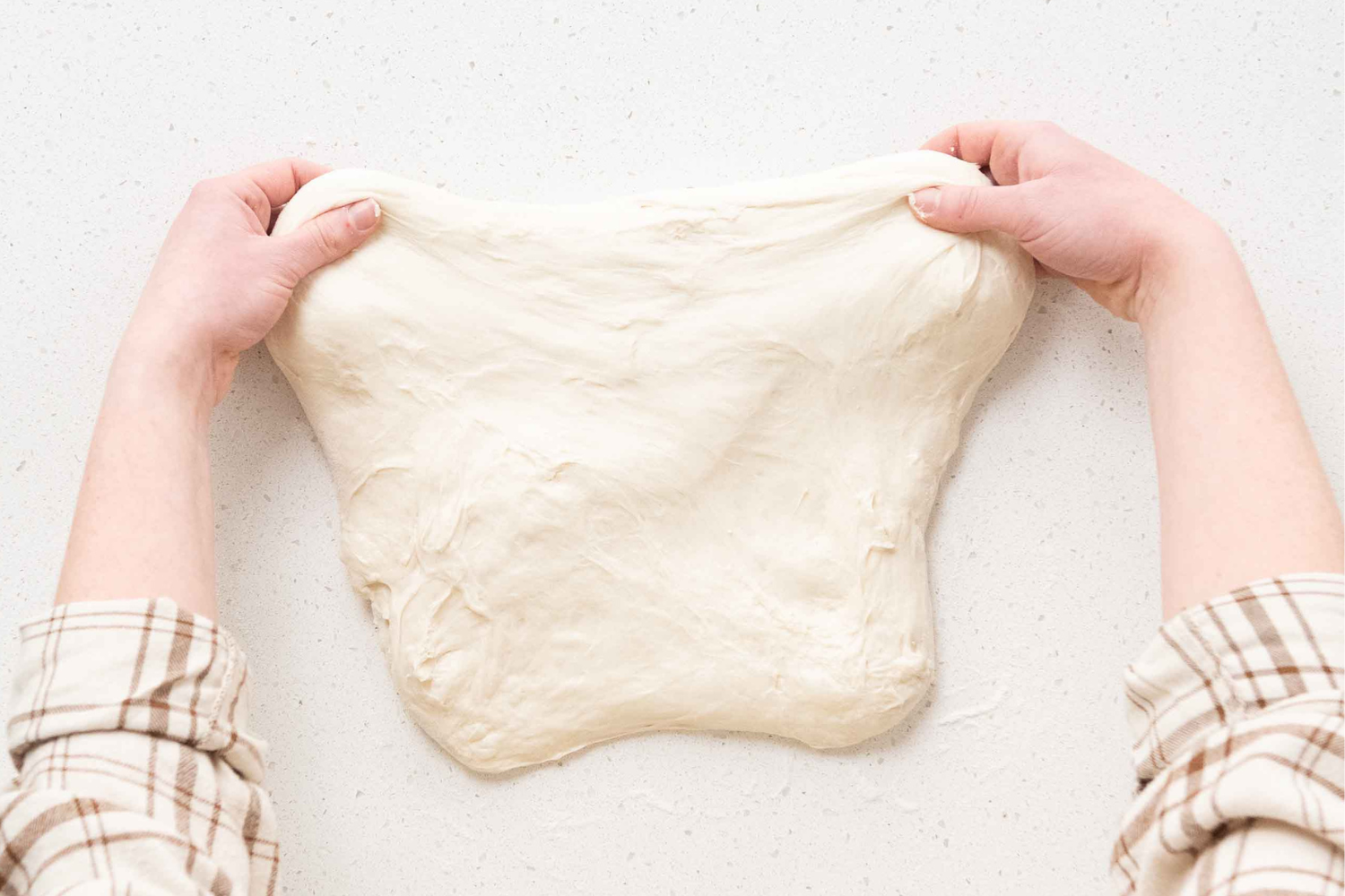 Stretching and shaping sourdough dough.