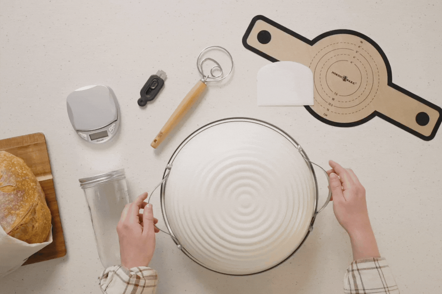 Hands removing lid from Deluxe 10 Piece Simply Sourdough Bread Baking Kit.