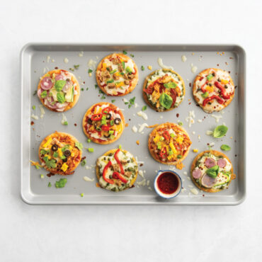 overhead of brilliant big sheet with various meat and veggie flat breads