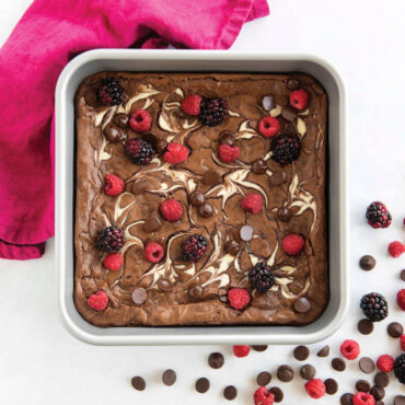 overhead of brilliant 9in square cake pan with brownie swirl topped with raspberries