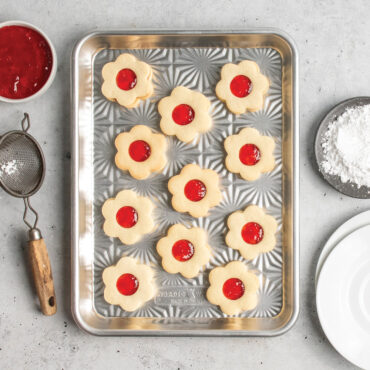 overhead of jam-filled novelty shaped cookies on starburst quarter sheet pan