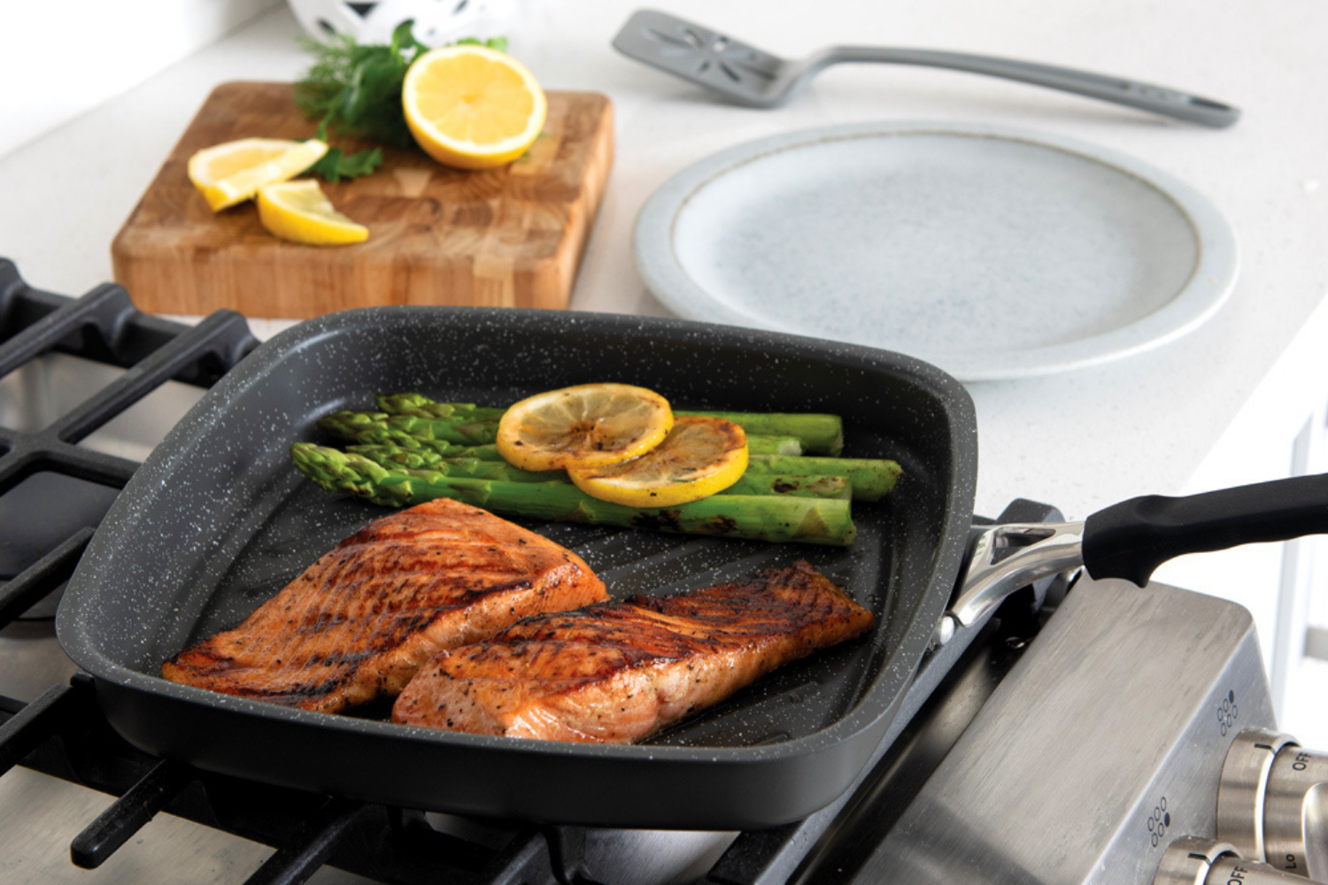 Salmon and vegetables cooking in the Nordic Ware Verde Ceramic Nonstick Searing Grill Pan. 