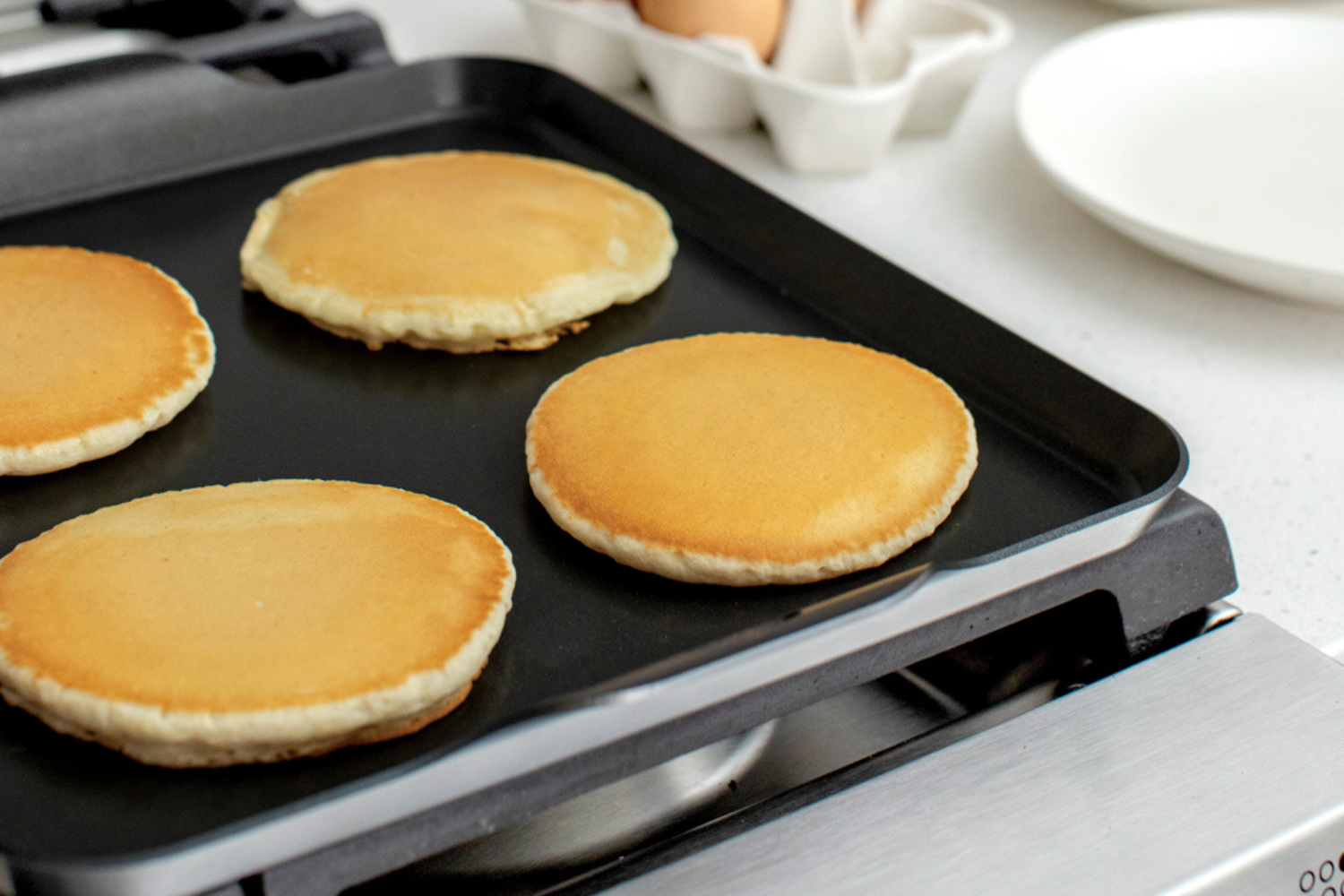 Sourdough pancakes cooking on griddle. 