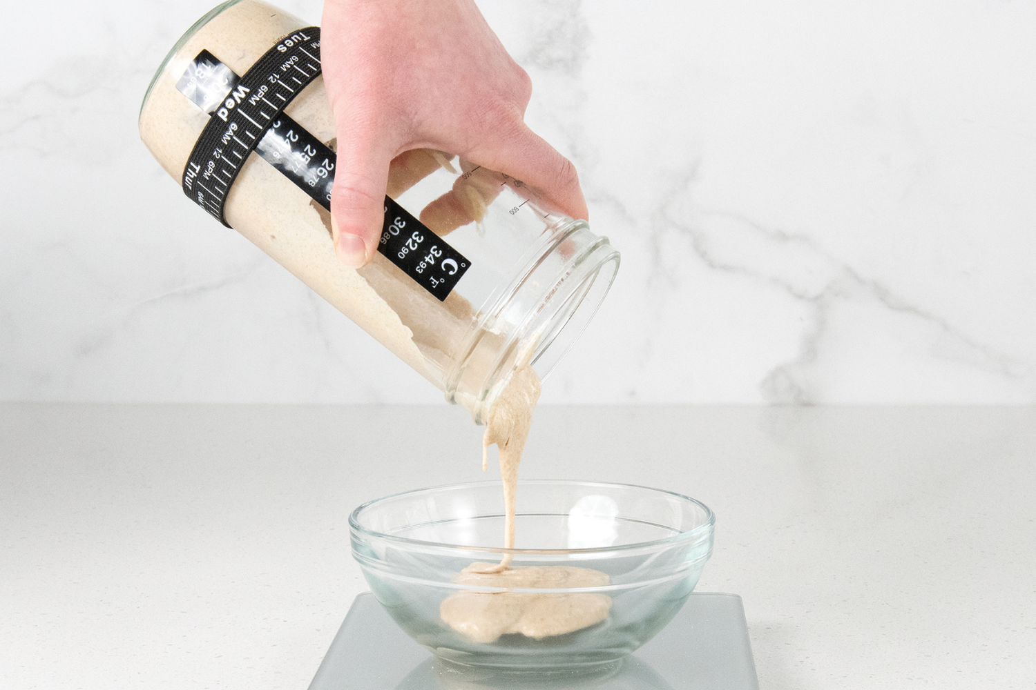 Sourdough starter being poured into a bowl. 