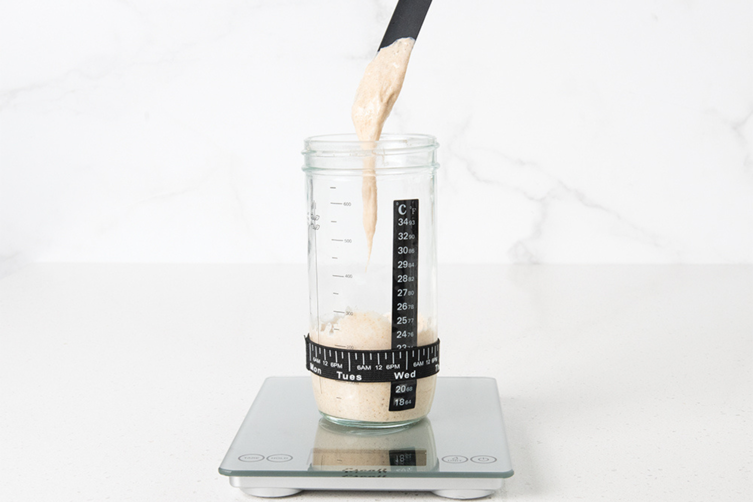 Removing sourdough starter from a jar.