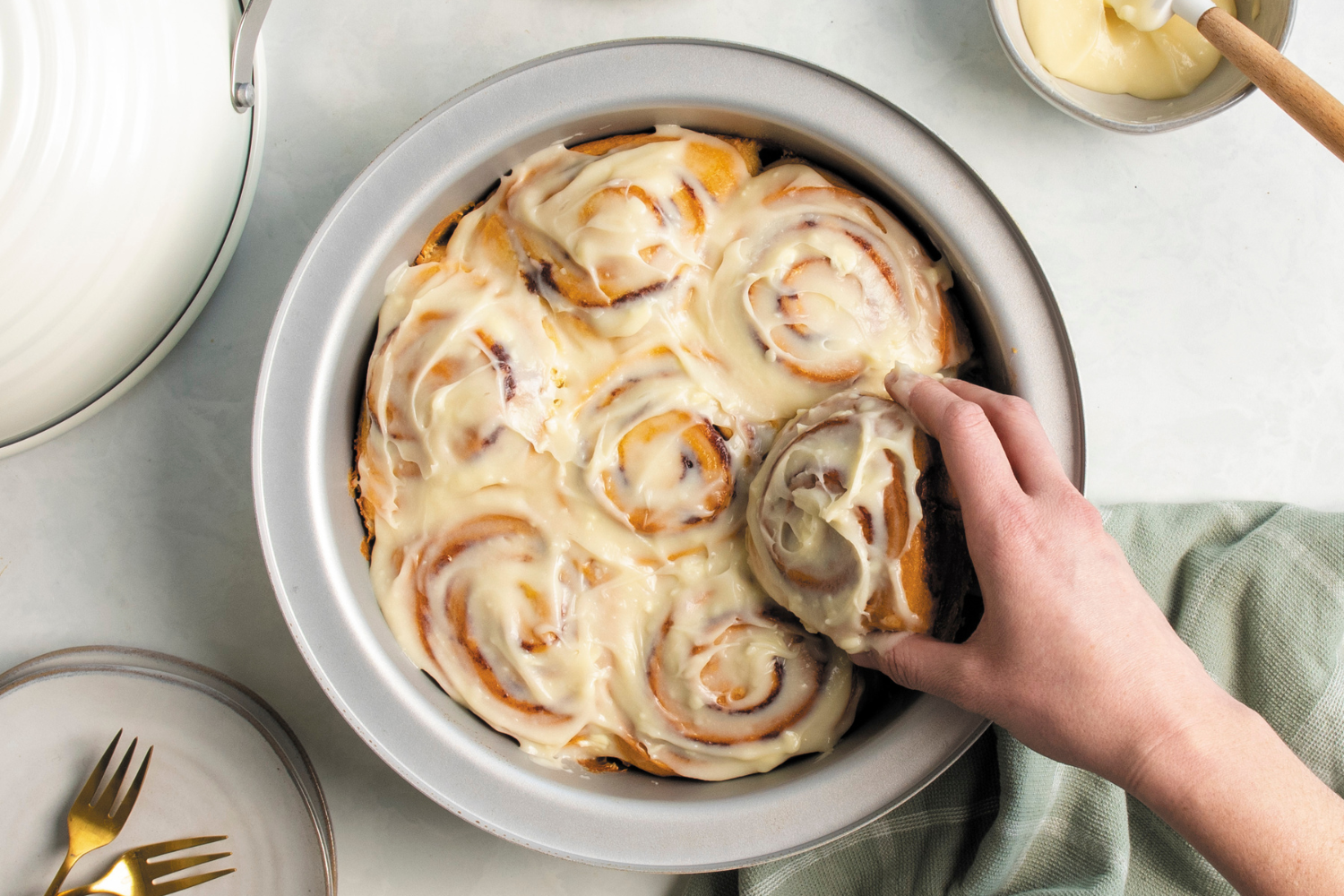 Removing a sourdough cinnamon roll from the Basic 9 Piece Simply Sourdough Bread Baking Kit