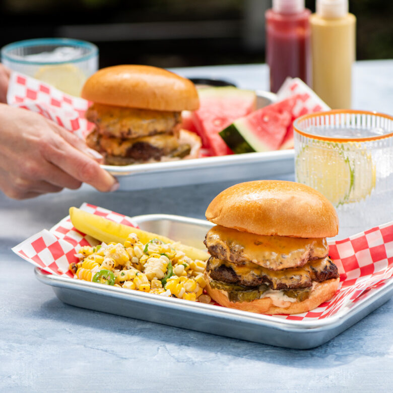  Image of smash burgers and sides on Nordic Ware's Eighth Sheet Pans in outdoor scene