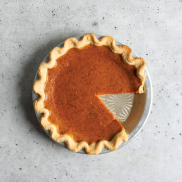 overhead of cut pumpkin pie inside nordic ware vintage starburst pie pan