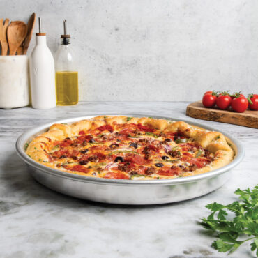 deep dish pizza pan with supreme style pizza staged on countertop