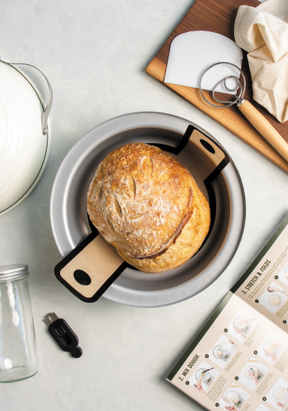 Lifestyle image of Basic Sourdough Baking Kit with tools included and baked bread in the middle base/