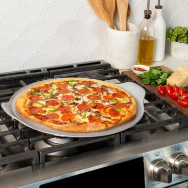 nordic ware aluminized steel pizza & baking steel pan on stovetop with pizza