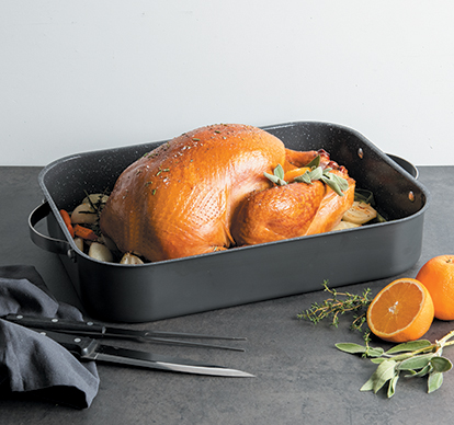 Image of Nordic Ware Ceramic Nonstick Verde Grand Roaster with a cooked turkey and ingredients on surface